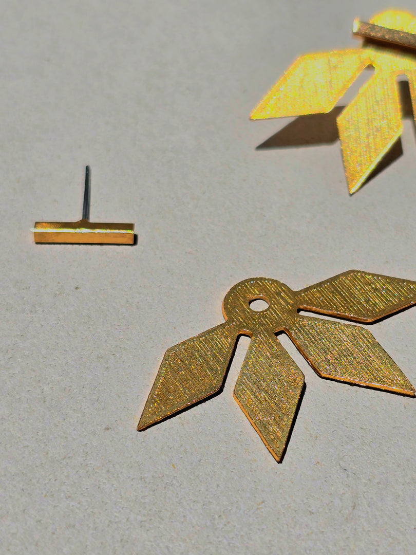 Aretes Su´usi Flor Dorada J con detalles de fabricación