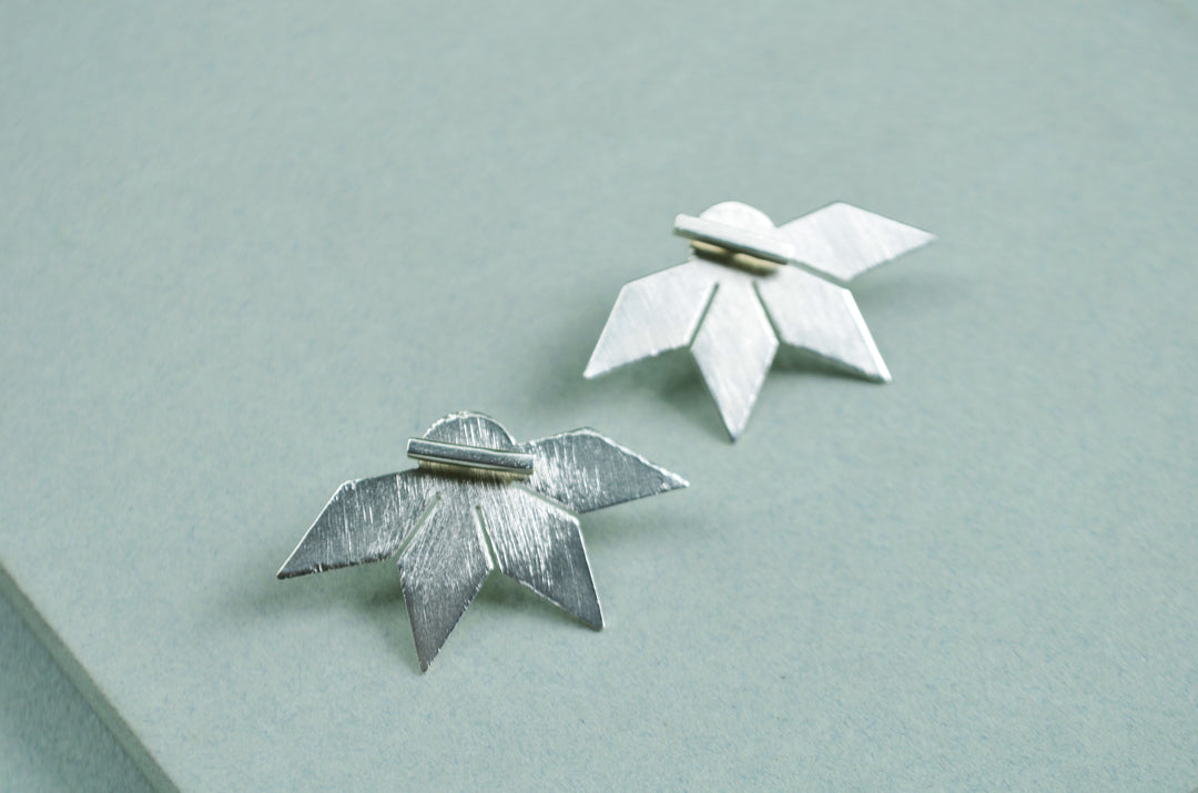 Aretes Su´usi Flor Plateada L con detalles de fabricación