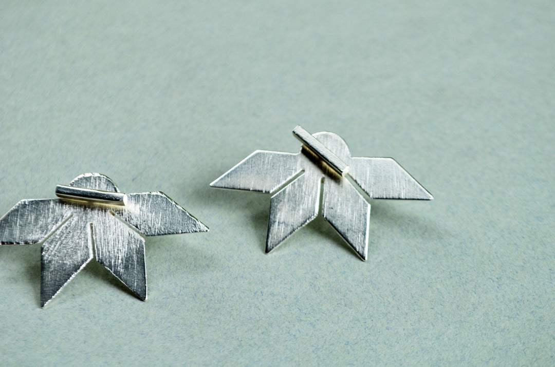 Aretes Su´usi Flor Plateada L con detalles de fabricación
